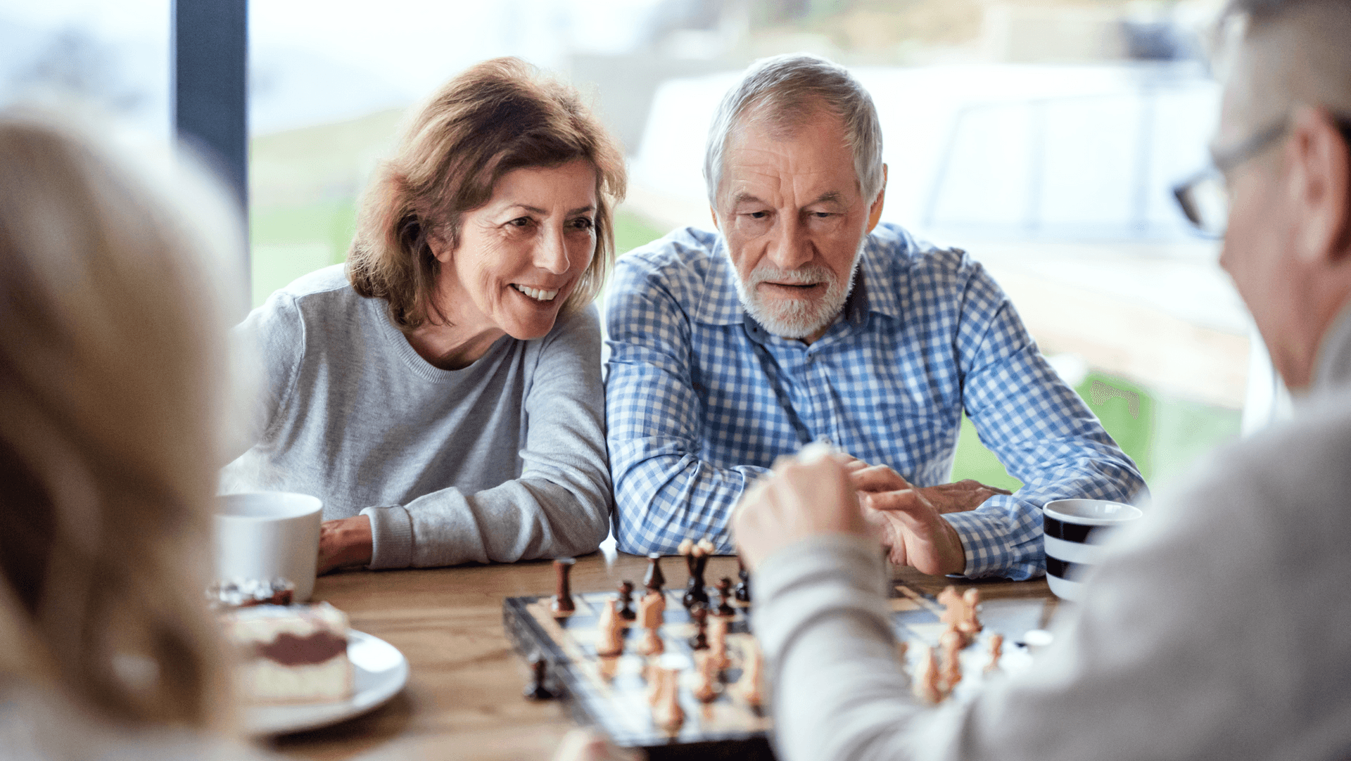 A couple play chess with friends