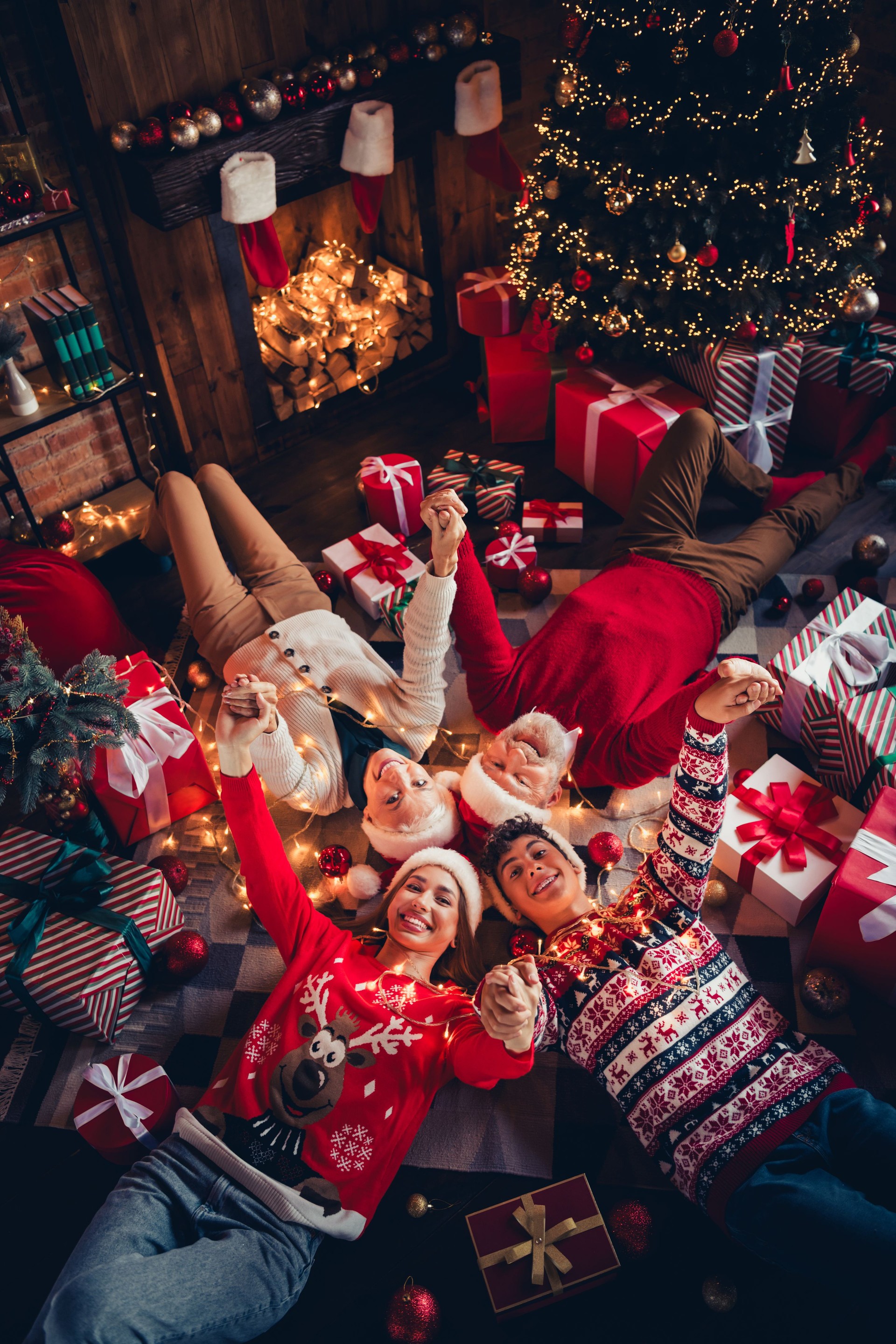 Top view photo of happy family lying floor with gift box raise hands have fun christmas time in house indoors