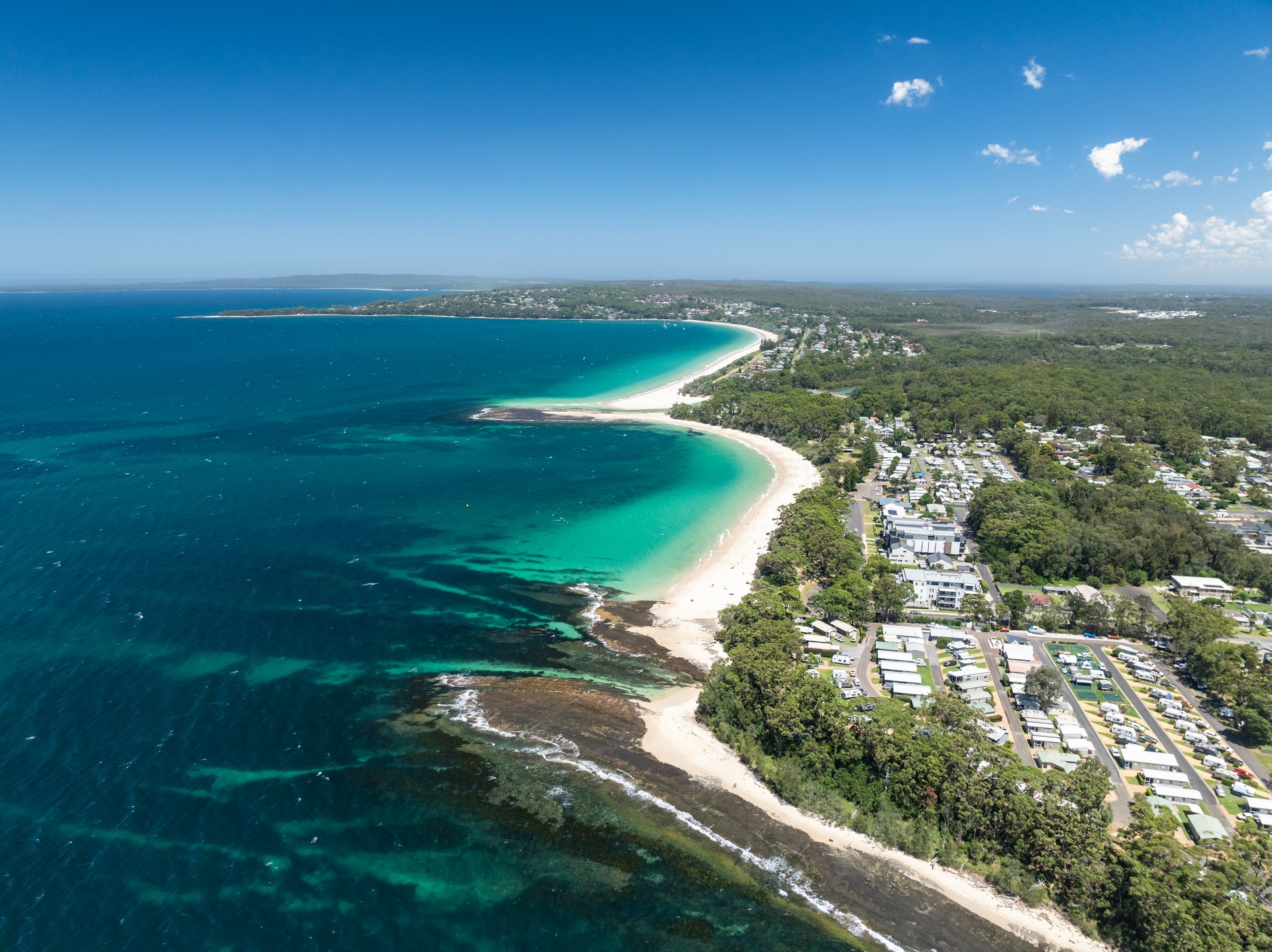 High angle aerial drone view of Huskisson Beach and Collingwood Beach in Huskisson and Vincentia, beachside suburbs in Jervis Bay Territory and on the South Coast of New South Wales, Australia.