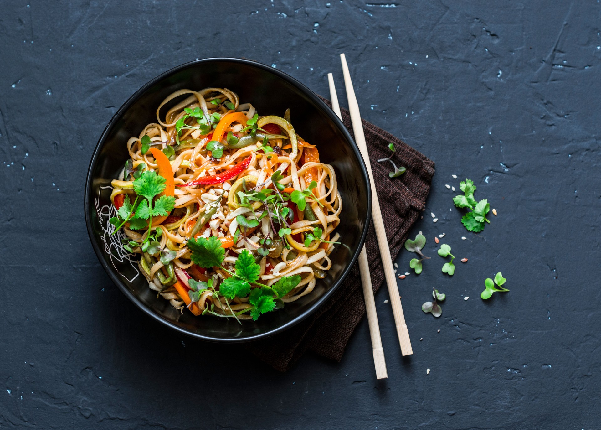 Pad Thai vegetarian vegetables udon noodles in a dark background, top view. Vegetarian food in asian style. Copy space