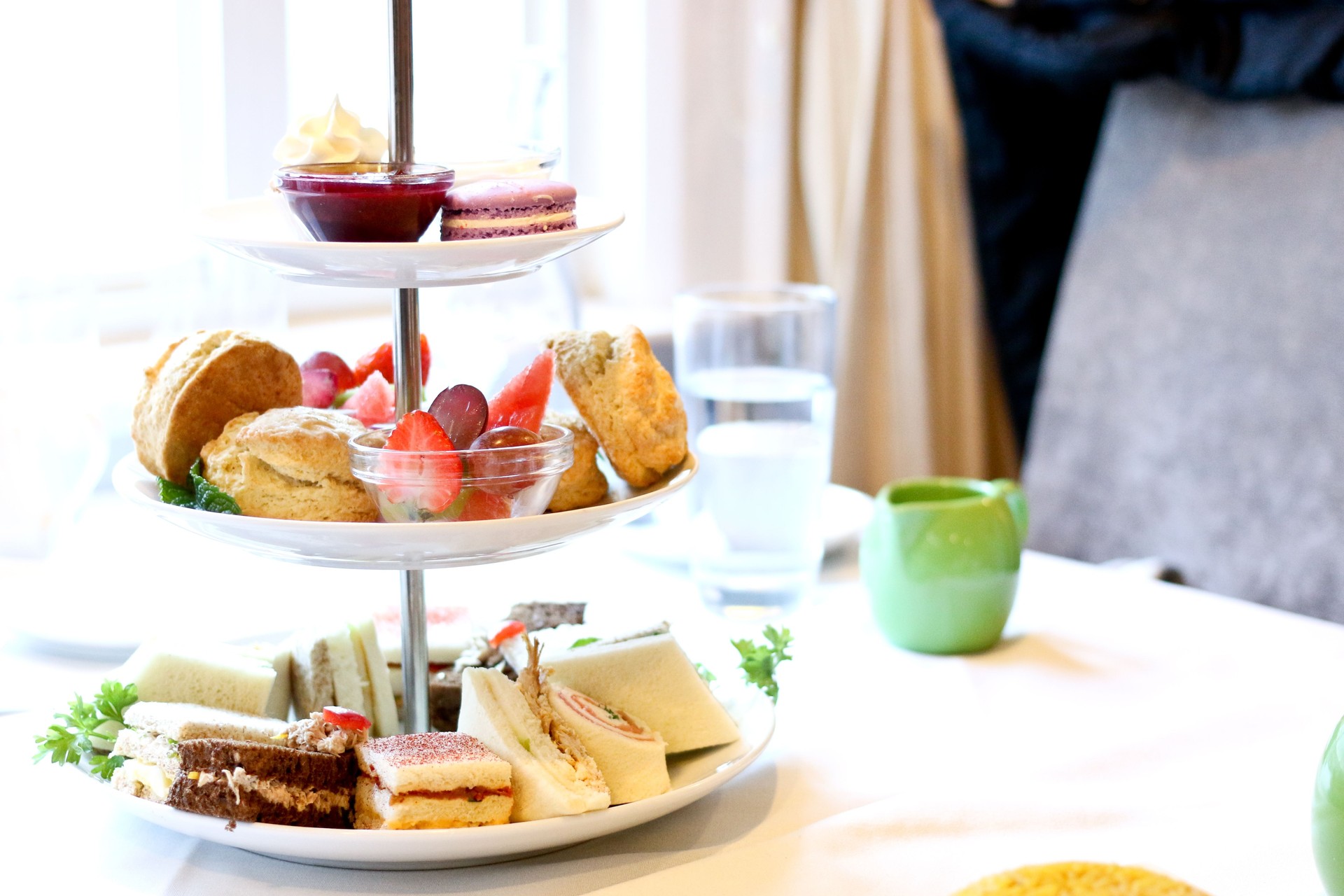 Afternoon tea three tier stand of desserts, fresh fruits, pastries and sandwiches